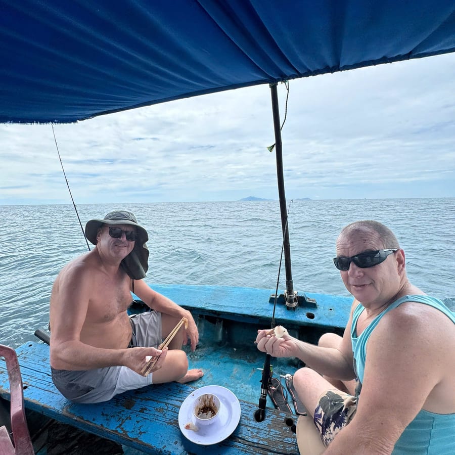 Guests resting on the shaded deck of the fishing boat