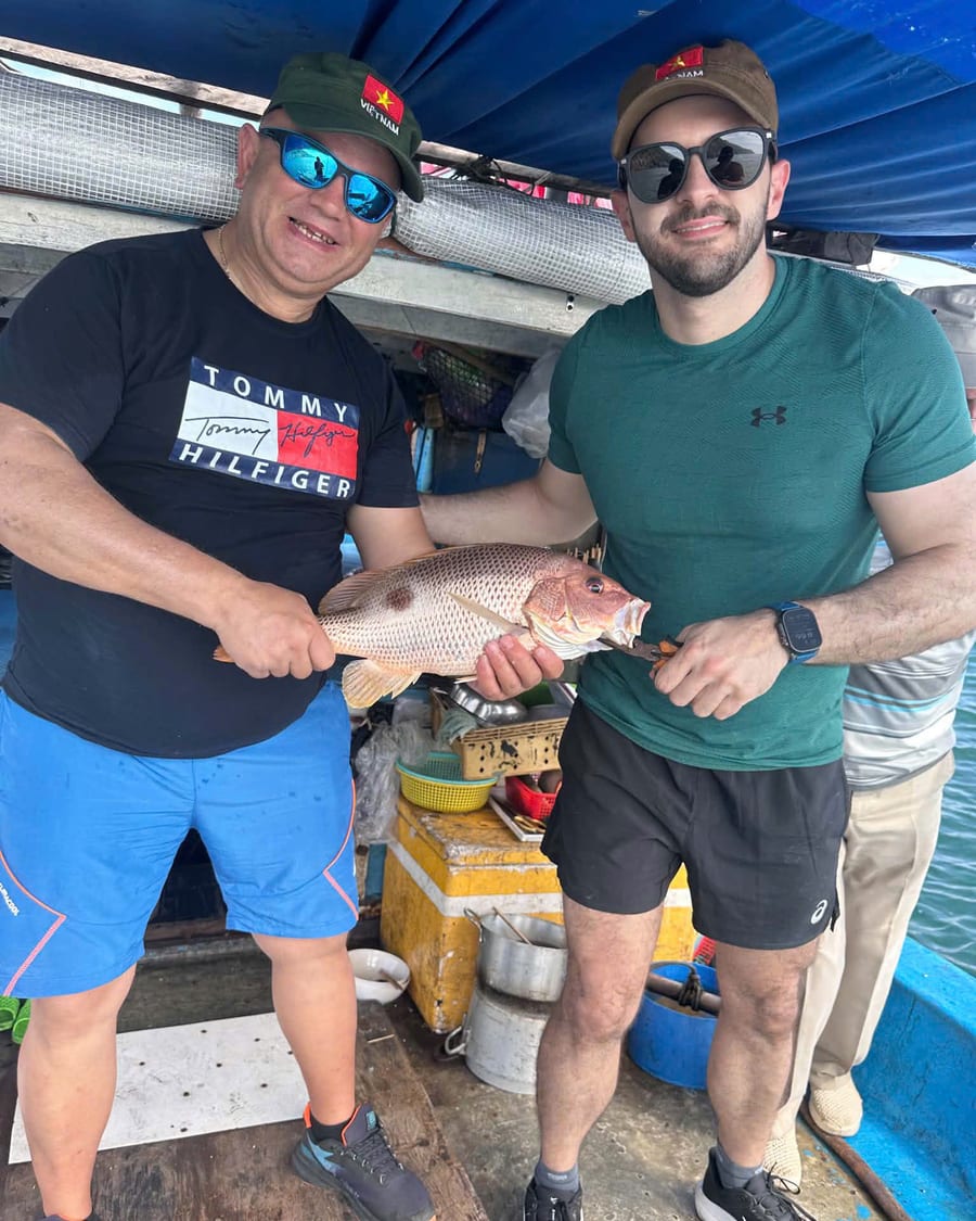 Two guests holding a fish caught on a Phu Quoc fishing tour